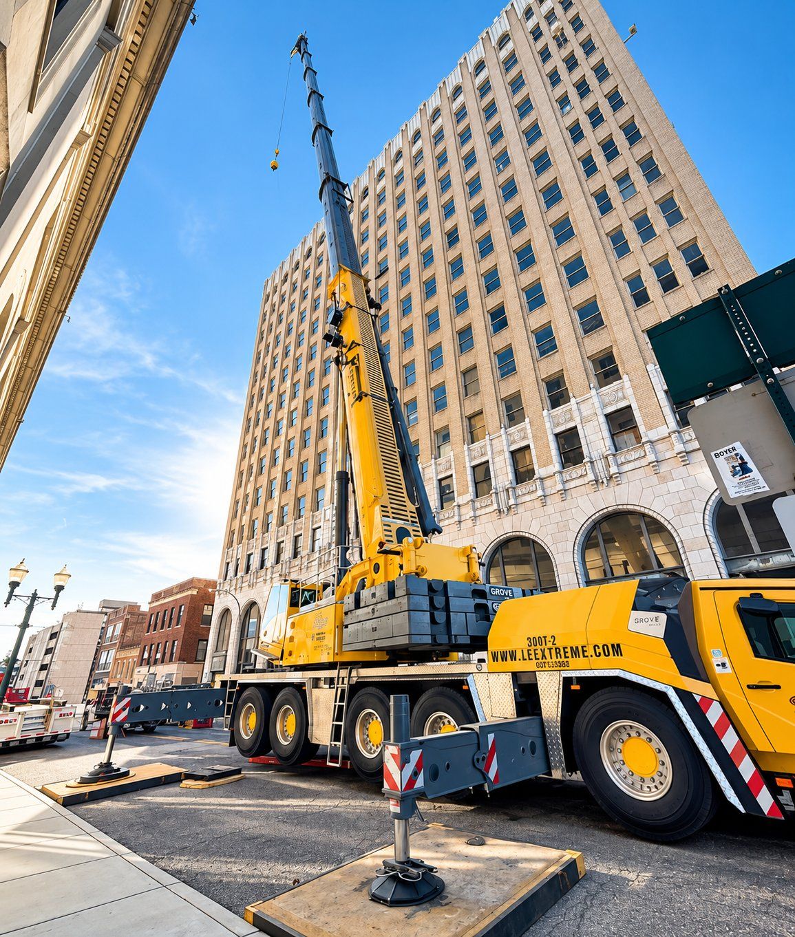 Crane lifting materials beside a historic tower under renovation