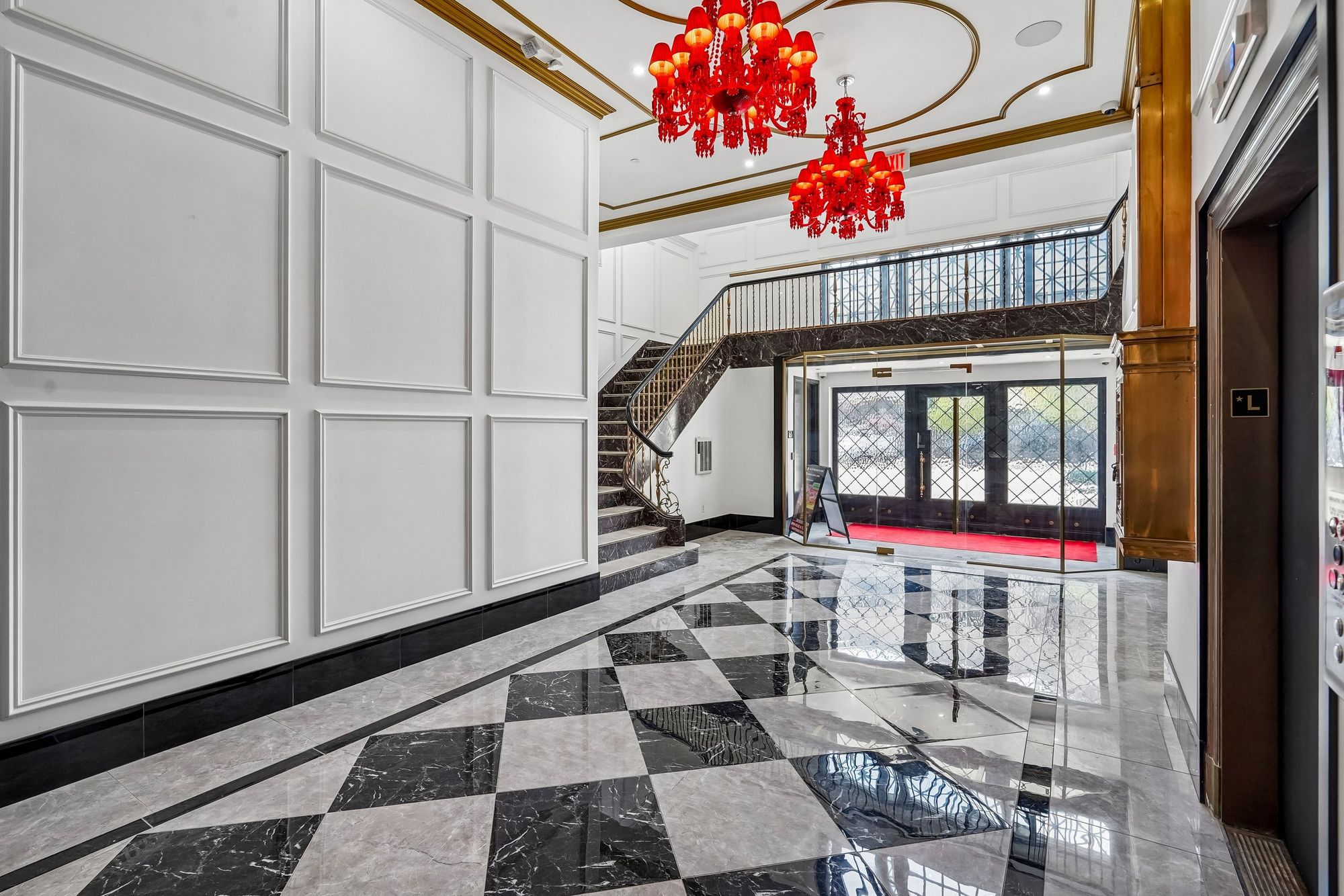 Lobby with a checkerboard marble floor and red glass chandeliers